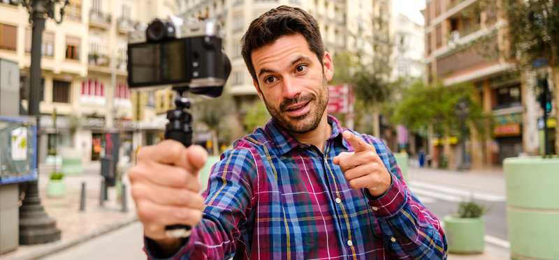 Person standing in city and talking into camera.