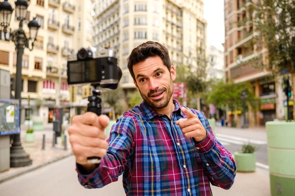 Person standing in city and talking into camera.
