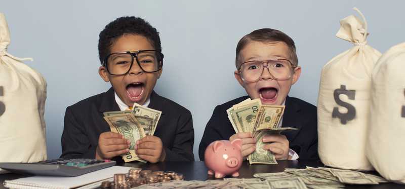 Two children are holding cash and looking amazed and happy.