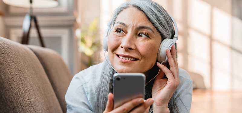 Person listening to their phone and smiling.