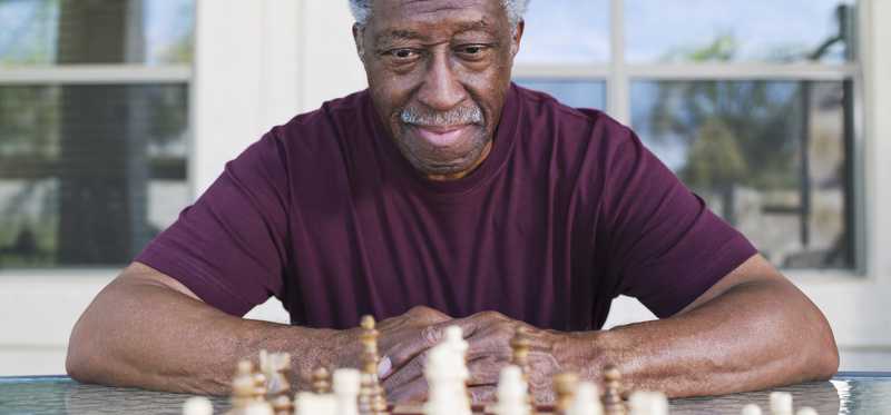 A person is staring at a chess board and thinking.
