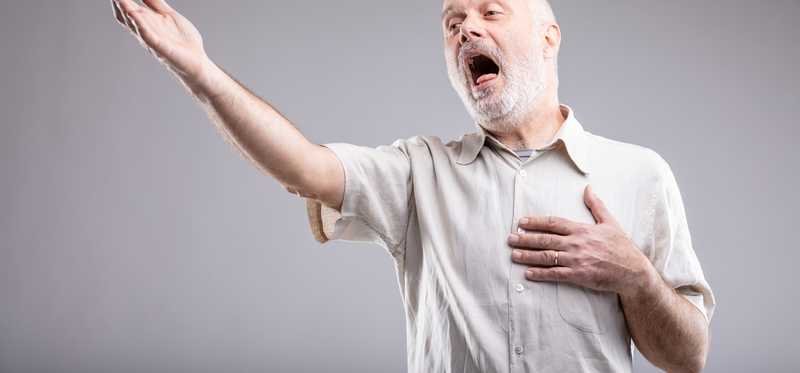 Person singing with their arms dramatically outstretched.
