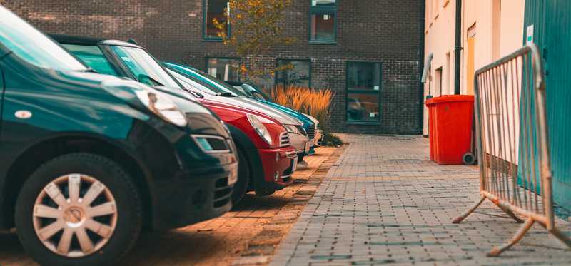 A row of cars in a small parking lot.