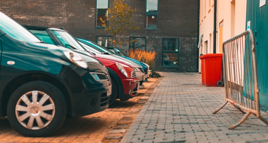 A row of cars in a small parking lot.