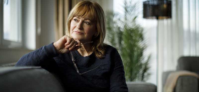 A person is on a sofa, seemingly deep in thought.