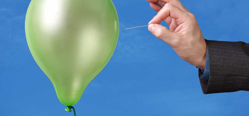 We see a hand with a pin about to burst a balloon.