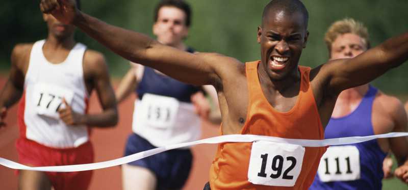 A runner is crossing the finish line first.
