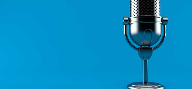 We see an old-fashioned microphone against a blue background.