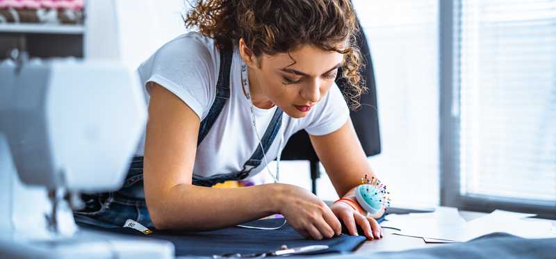 Woman sewing next to a sewing machine