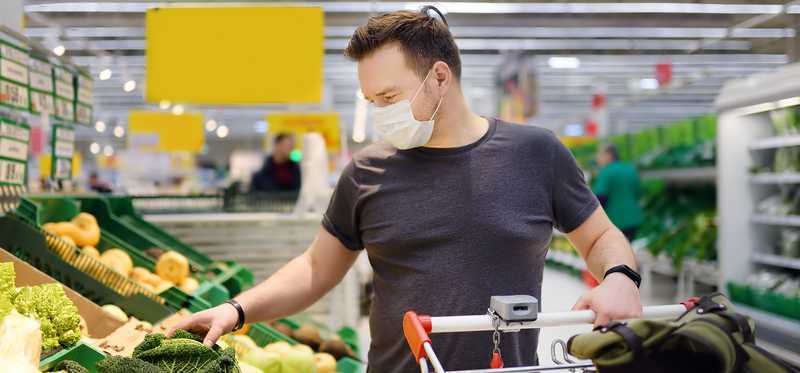 Person shopping in a supermarket while wearing a mask.