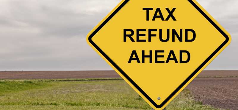 A road sign says Tax Refund Ahead.
