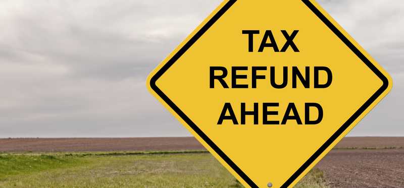 A road sign says Tax Refund Ahead.