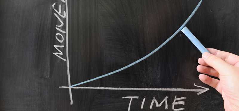 Graph drawn on a blackboard showing the value of money rising over time.