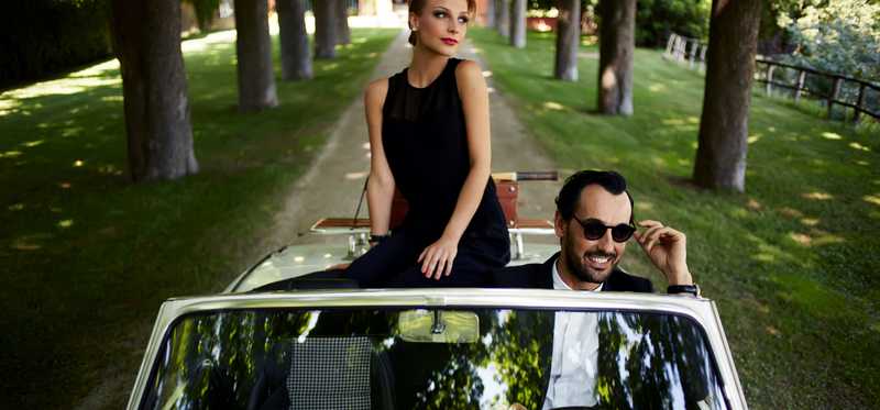 We see a seemingly wealthy young couple in a fancy car.