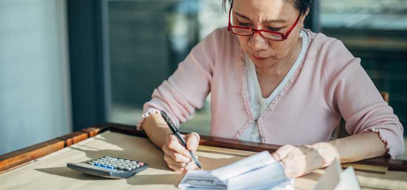 A person is studying and calculating at a desk.