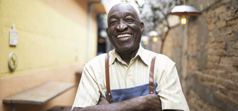 A worker is smiling with arms crossed.