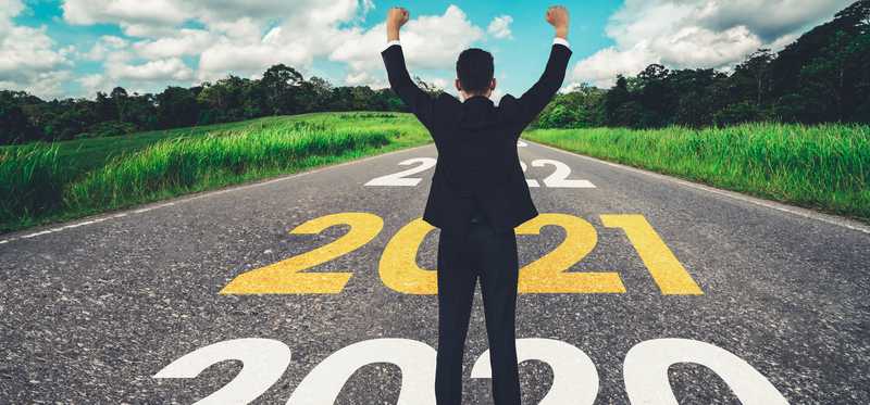 Man on a road on which is painted 2020 and 2021