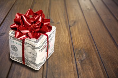 A gift box wrapped in money and a bow.