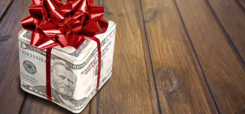 A gift box wrapped in money and a bow.