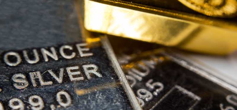 Gold and silver bars laid messily next to one another.