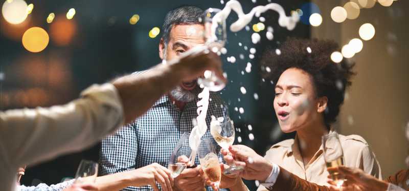 Champagne flows as a group of people toast.