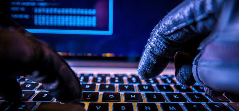 Gloved hands typing on a computer