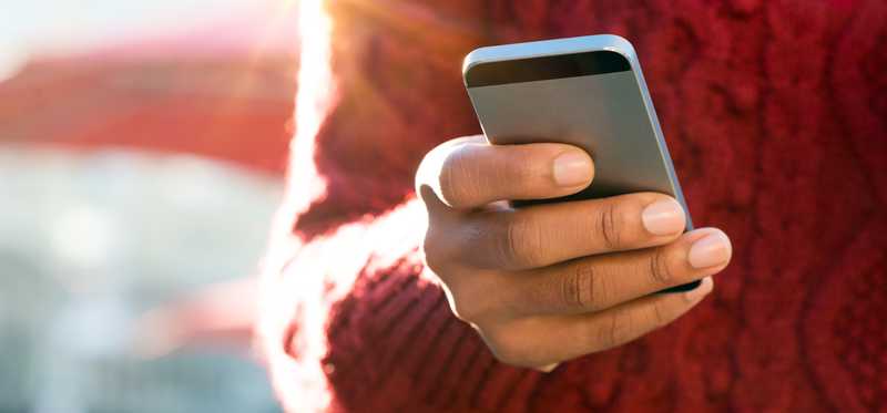 Person in sweater is holding phone.