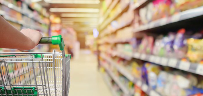 Hand on handle of grocery cart going down aisle