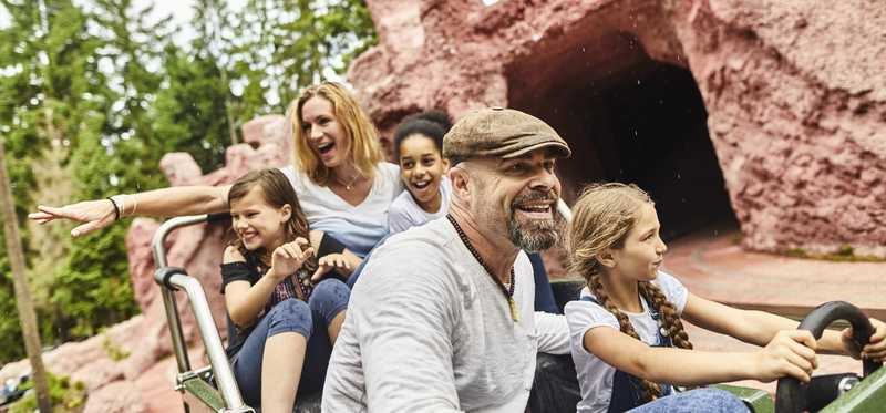 Adults and children on an amusement park ride.