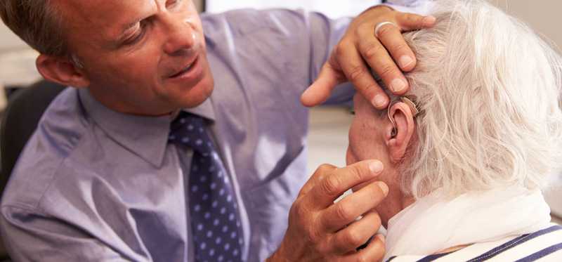 A doctor checks a patient's ear.