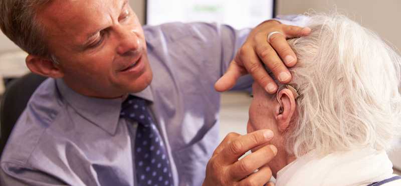A peron is being fit with a hearing aid