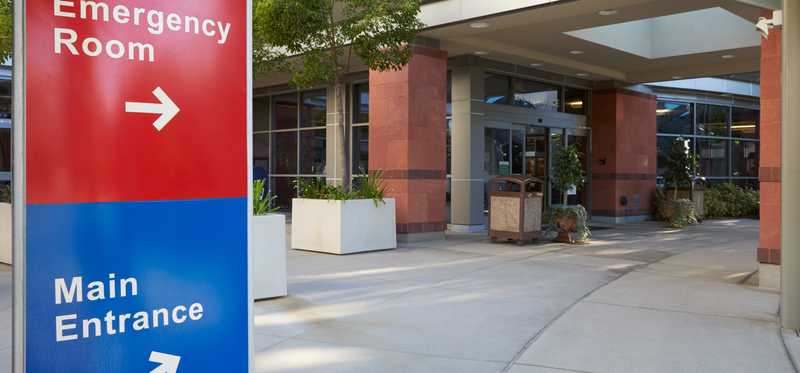 Signs for emergency room and hospital main entrance.