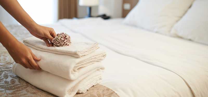 Extra blankets folded on the end of a hotel bed.