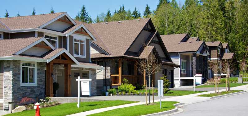 A suburban street with numerous houses for sale.