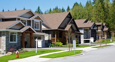 A suburban street with numerous houses for sale.