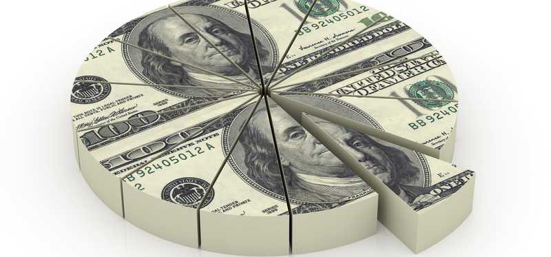 Hundred dollar bills formed into a circle and split into sections like a pie.