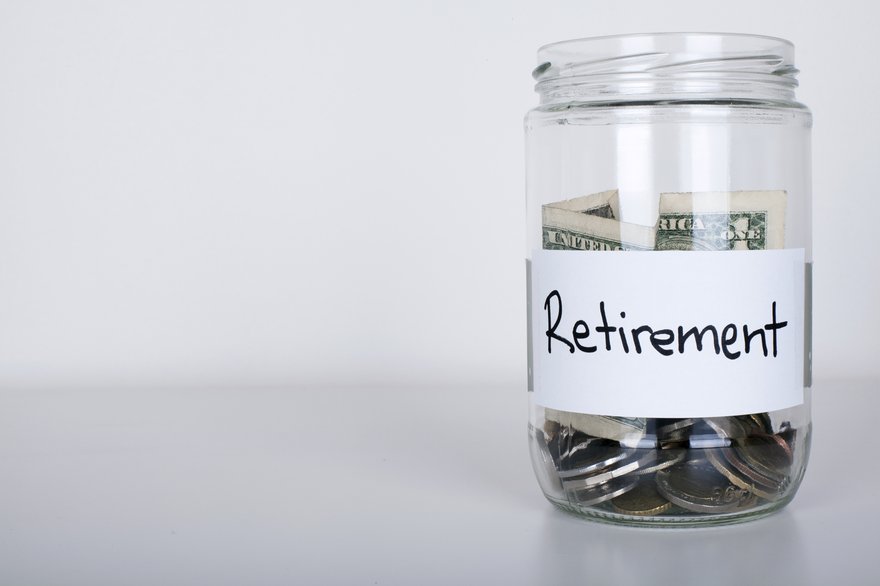 Jar labeled Retirement and half-filled with cash and coins