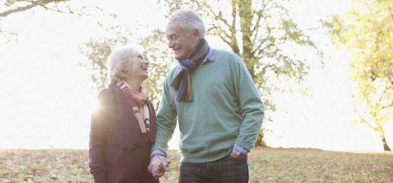 Two people holding hands in a park.