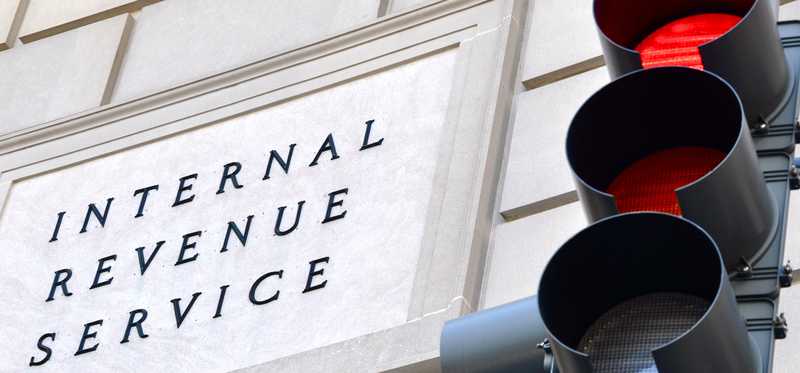 The IRS building seen next to a traffic light lit up red.