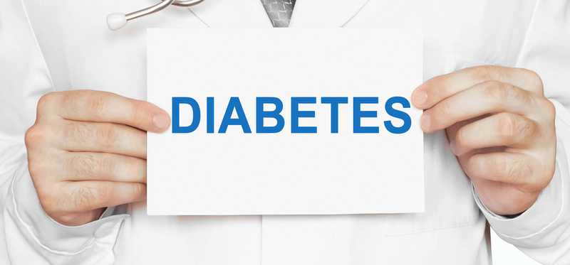 Physician holding up a paper reading Diabetes.