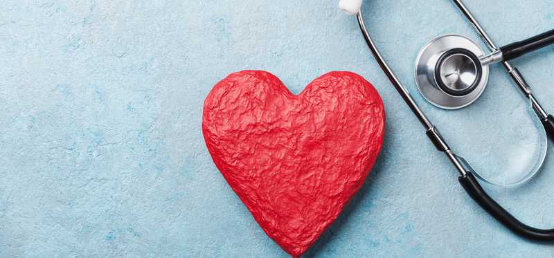 A red paper heart next to a stethoscope.