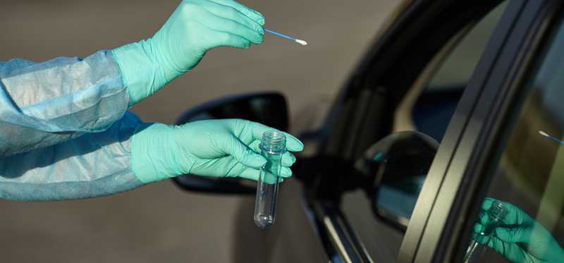 COVID test being administered at a drive-up facility.