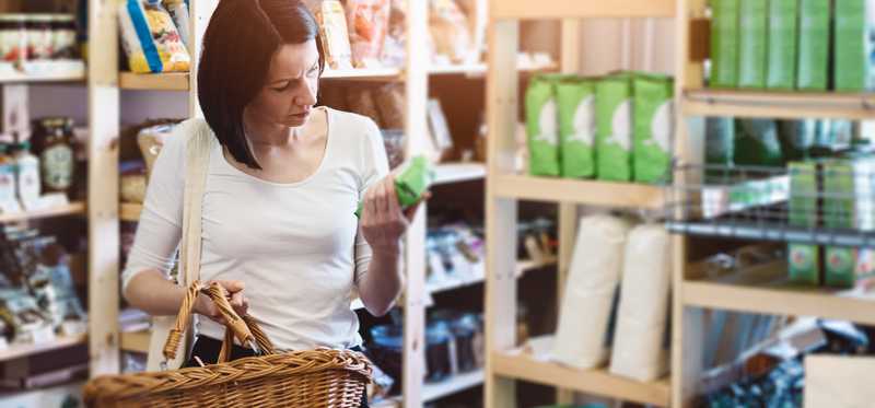 A woman puts products in her shopping basket.