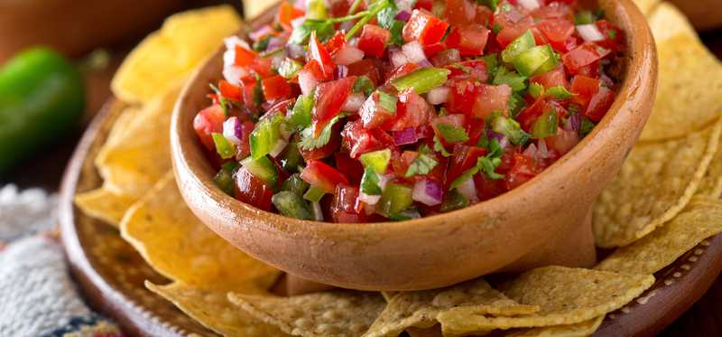 A bowl of salsa and tortilla chips.
