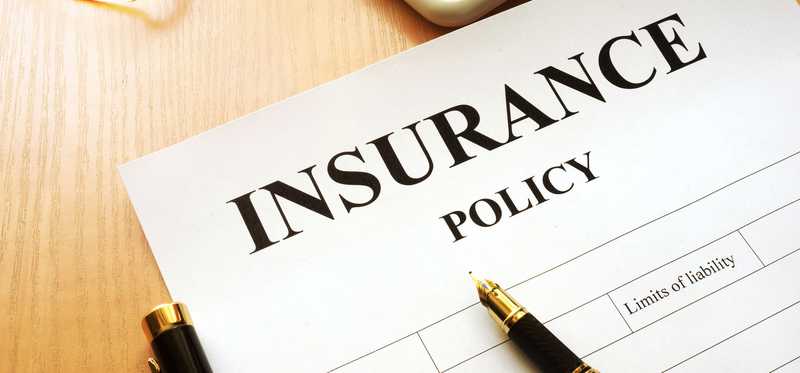 Insurance policy document with a pen lying on top.