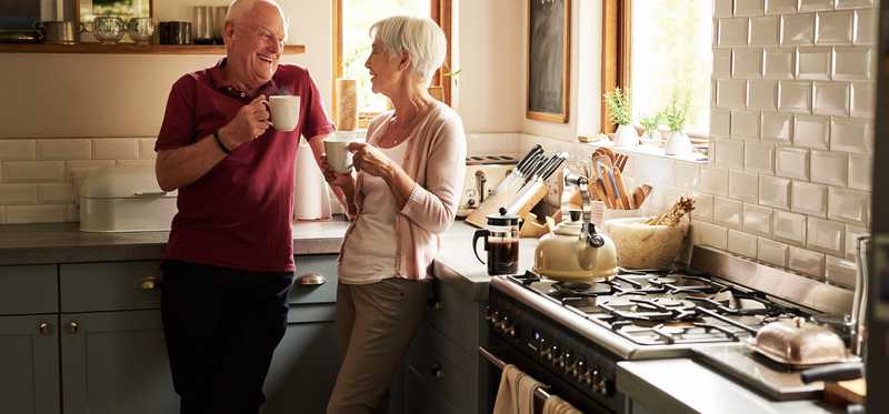 Senior couple drinking coffee in the kitchen