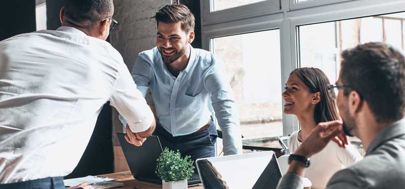 A group of young professionals interact around a table.