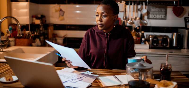 Person paying bills at kitchen table