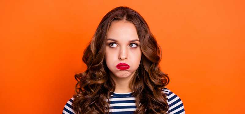 Woman in striped shirt pouting and looking disappointed