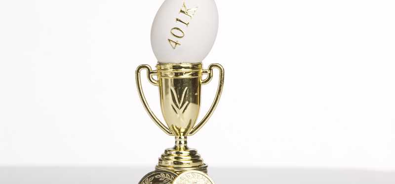 A gold trophy with an egg sticking out the top that reads 401k.